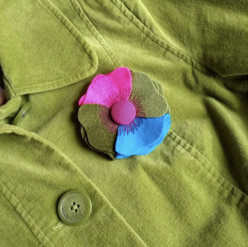 Petunia handmade four colour merino wool felt brooch on a green jacket Petunia handmade four colour merino wool felt brooch on a green jacket