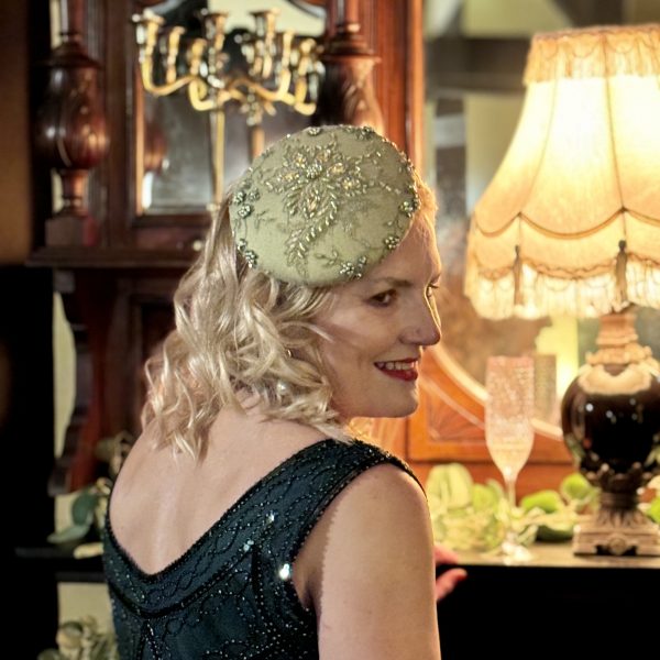Jeanette wears Emily - a mid size perching beanie style headpiece in chartreuse coloured jewelled lace