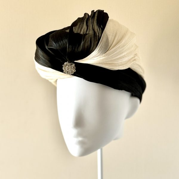 Tiffany – a turban in ivory and black silk abaca finished with a semi-bow left