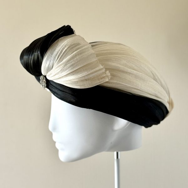Tiffany – a turban in ivory and black silk abaca finished with a semi-bow left