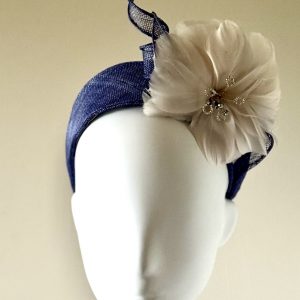 Charlotte - a sinamay blue halo finished with an oyster coloured feather flower - facing